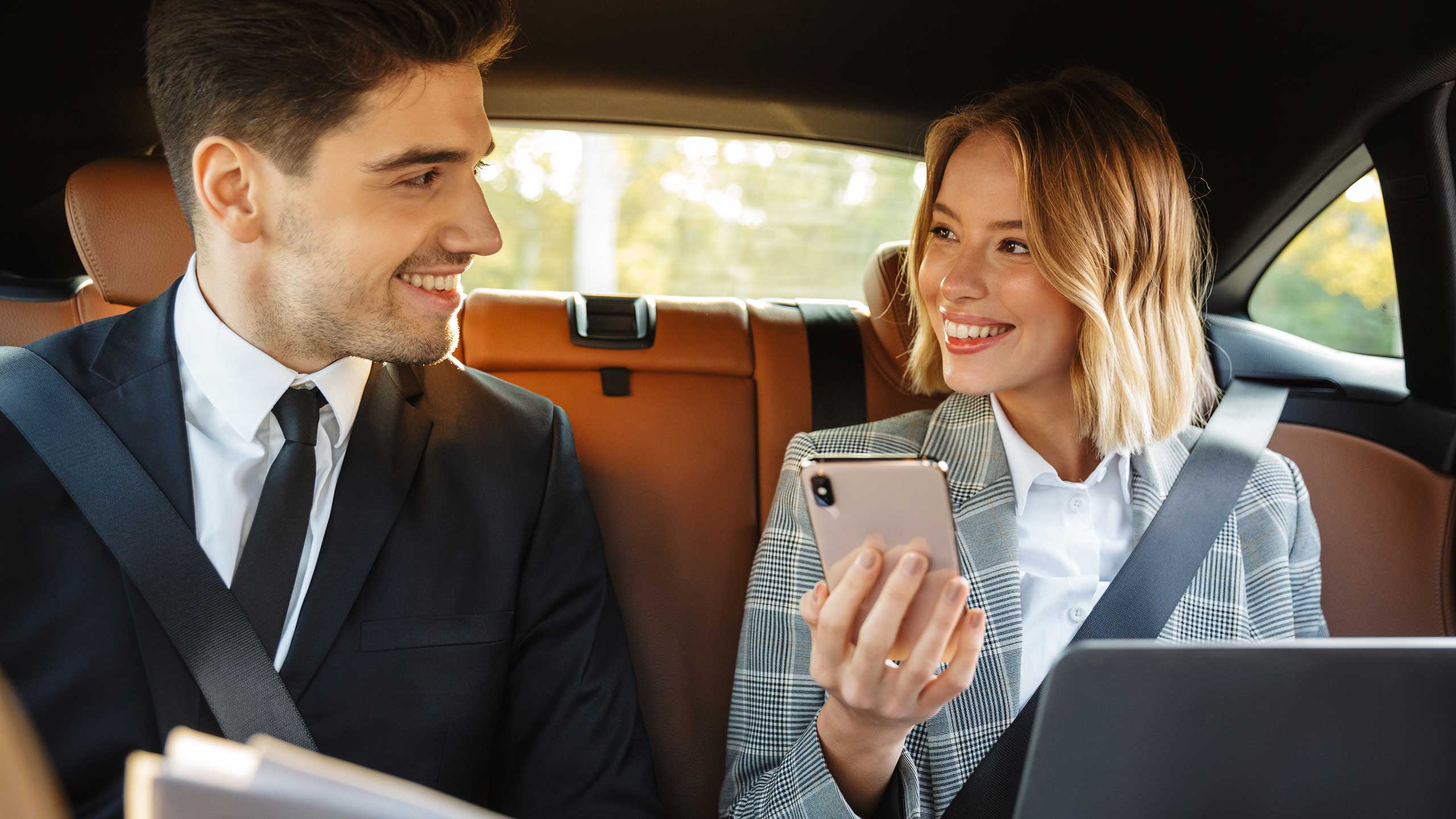 Geschäftsmann und Frau in Auto mit Smartphone